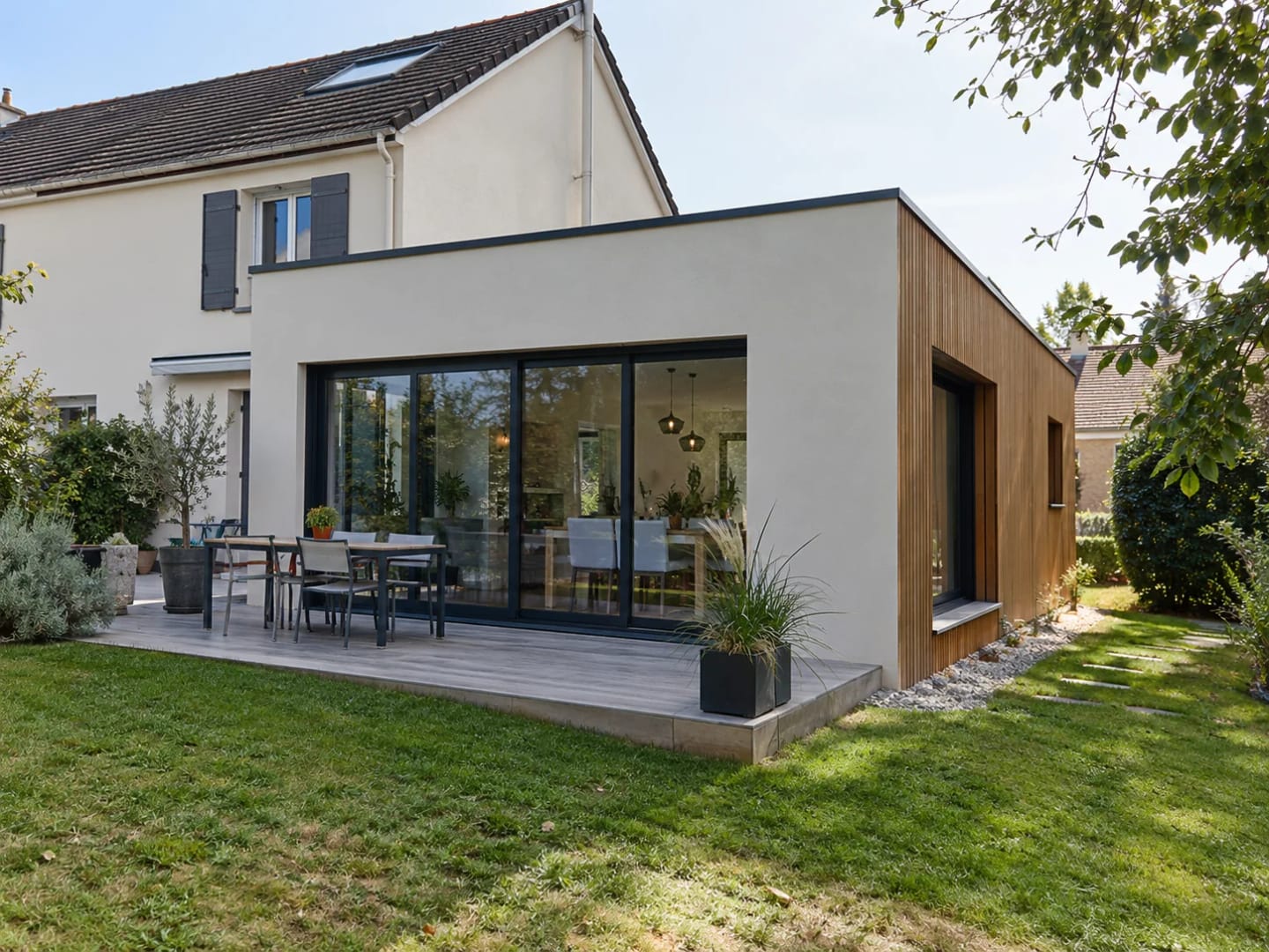 Extension contemporaine en bois accolée à une maison individuelle.