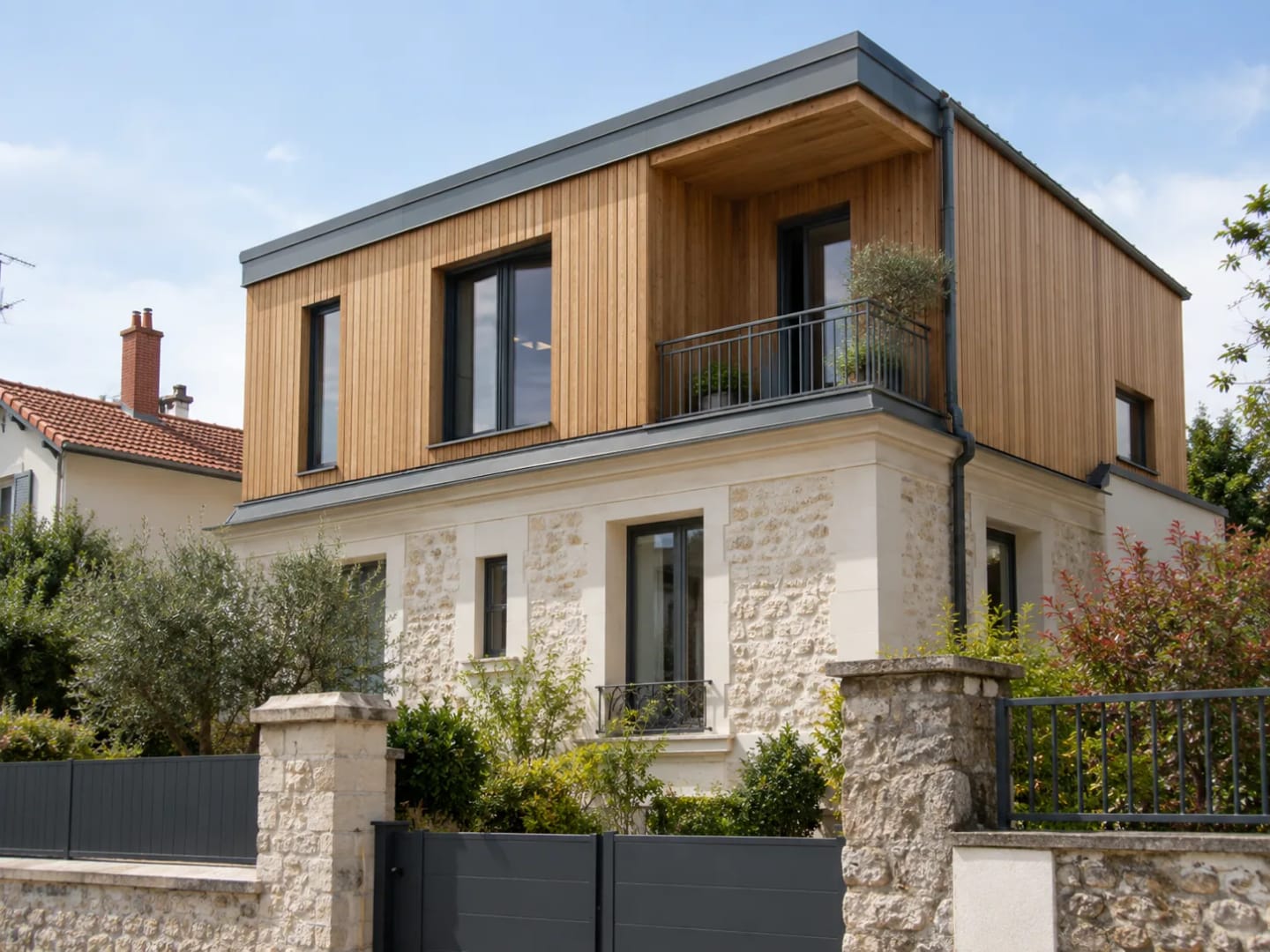 Maison associant une construction en ossature bois et une façade en pierre.